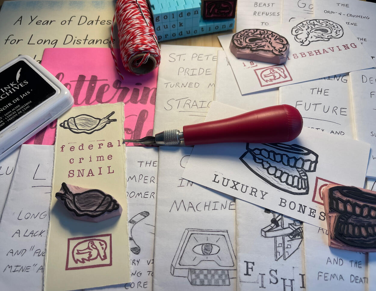 A spread of various papercraft art projects from Golden Duck Productions, as well as tools used in their production.